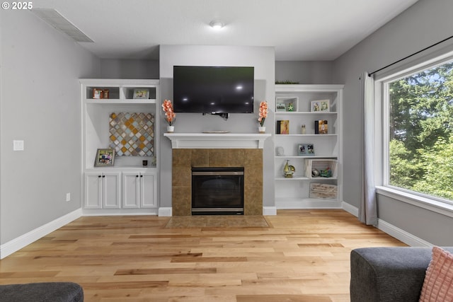 14818 NE 23rd Ave, Vancouver, WA 98686 - living room featuring light wood-style floors, a tile fireplace, and built in shelves
