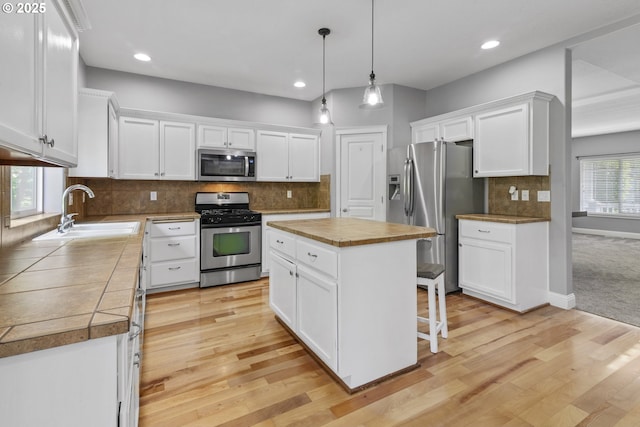 14818 NE 23rd Ave, Vancouver, WA 98686 - kitchen with stainless steel appliances, white cabinets, light wood-style flooring, a kitchen island, and recessed lighting