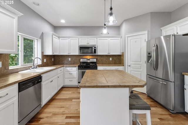 14818 NE 23rd Ave, Vancouver, WA 98686 - kitchen featuring appliances with stainless steel finishes, a center island, a breakfast bar area, white cabinets, and light wood finished floors