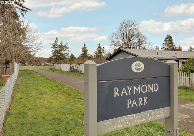 community sign featuring a lawn and fence