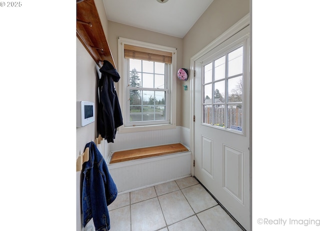 mudroom with light tile patterned floors and a wainscoted wall