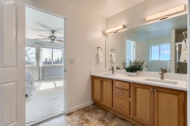 12998 SW Kostel Ln, Portland, OR 97224 - bathroom with a ceiling fan, double vanity, baseboards, and stone finish flooring