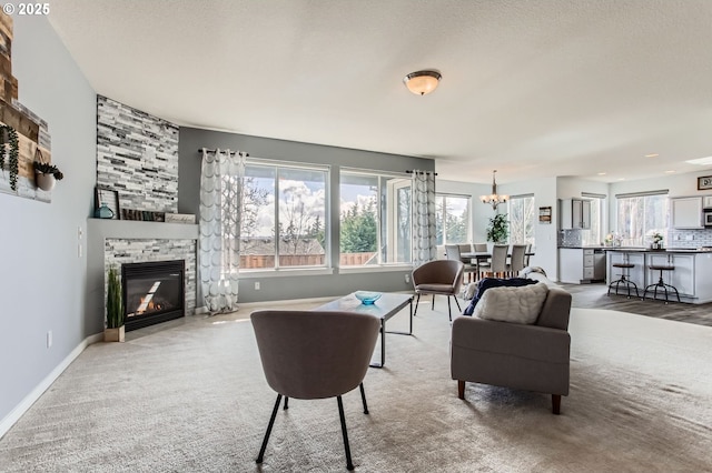 12998 SW Kostel Ln, Portland, OR 97224 - living room with a chandelier, a fireplace, baseboards, and light colored carpet
