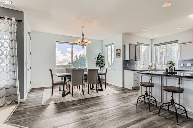 12998 SW Kostel Ln, Portland, OR 97224 - dining area with dark wood-style flooring, a chandelier, healthy amount of natural light, baseboards, and recessed lighting