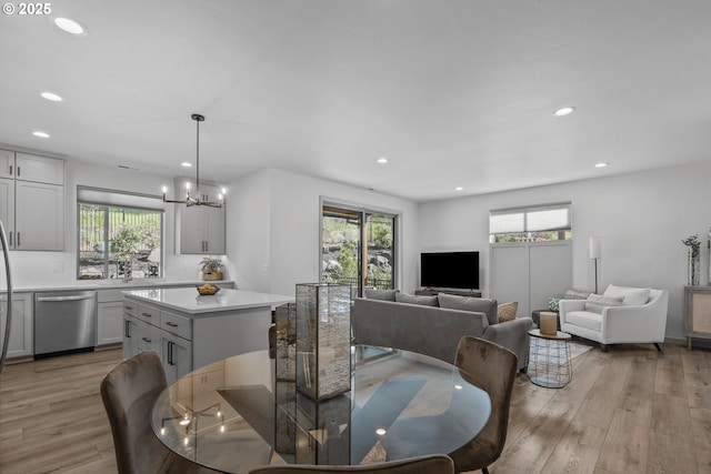 dining area featuring an inviting chandelier, plenty of natural light, and light wood finished floors