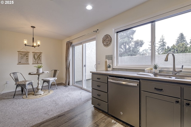 kitchen with gray cabinetry, a sink, light countertops, hanging light fixtures, and dishwasher