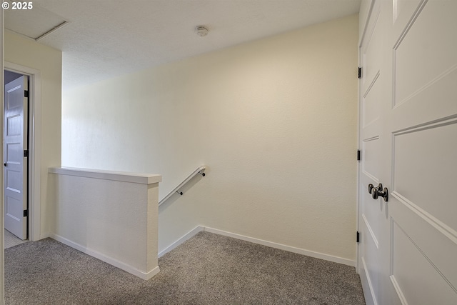 corridor with carpet floors, baseboards, and an upstairs landing