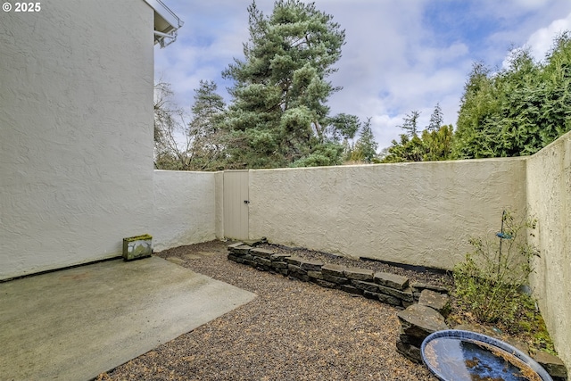 view of yard featuring a gate, a fenced backyard, and a patio