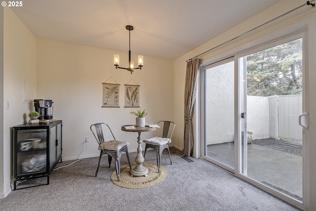 living area with a chandelier, carpet, visible vents, and baseboards