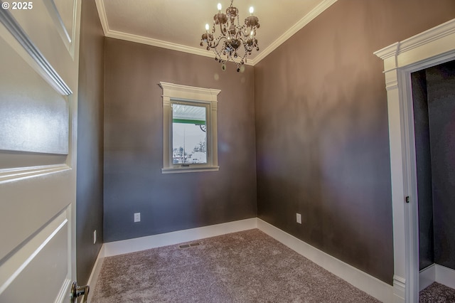 spare room featuring carpet floors, ornamental molding, and an inviting chandelier