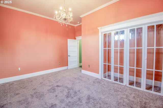 carpeted empty room featuring a chandelier and ornamental molding