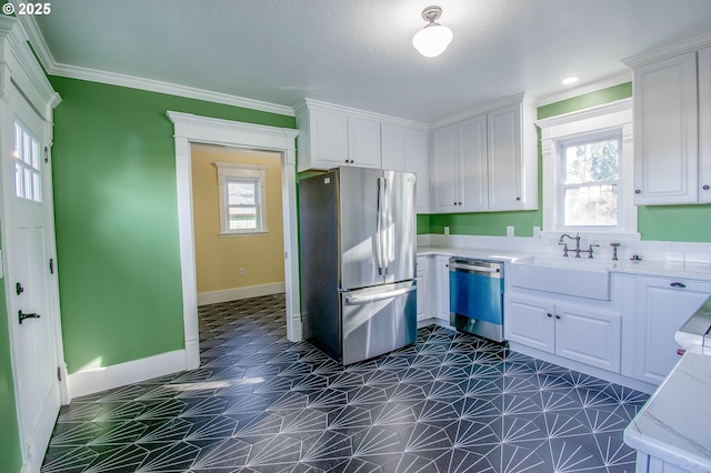 kitchen featuring sink, ornamental molding, white cabinetry, and appliances with stainless steel finishes