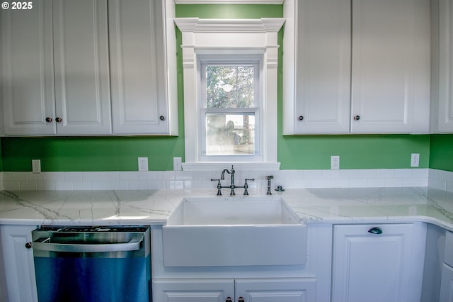 kitchen with sink, white cabinets, light stone countertops, and stainless steel dishwasher