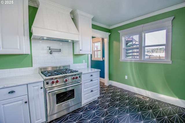 kitchen with premium stove, custom range hood, and white cabinetry