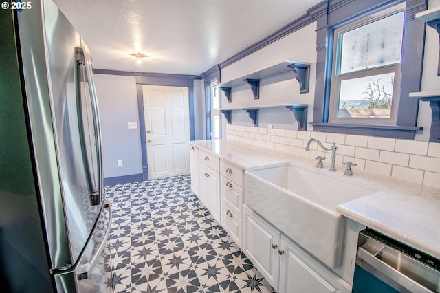 kitchen featuring sink, crown molding, white cabinets, and stainless steel appliances