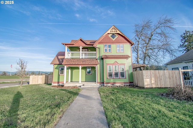 victorian-style house with a balcony and a front lawn