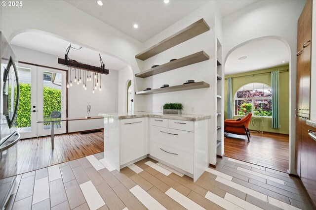 6035 NE 9th Ave, Portland, OR 97211 - kitchen featuring arched walkways, white cabinetry, open shelves, light stone counters, and recessed lighting