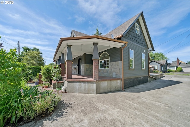 6035 NE 9th Ave, Portland, OR 97211 - view of front of house with a porch, stone siding, and a shingled roof