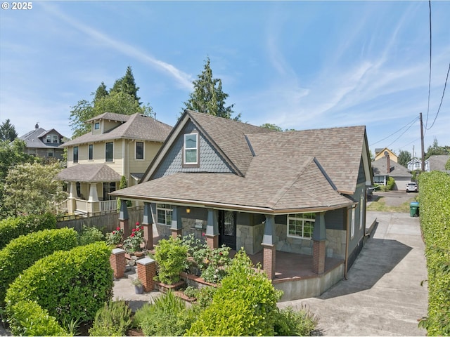 6035 NE 9th Ave, Portland, OR 97211 - view of front of property with roof with shingles, covered porch, stone siding, and a residential view