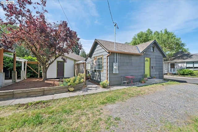 6035 NE 9th Ave, Portland, OR 97211 - view of front of house with roof with shingles and a storage unit