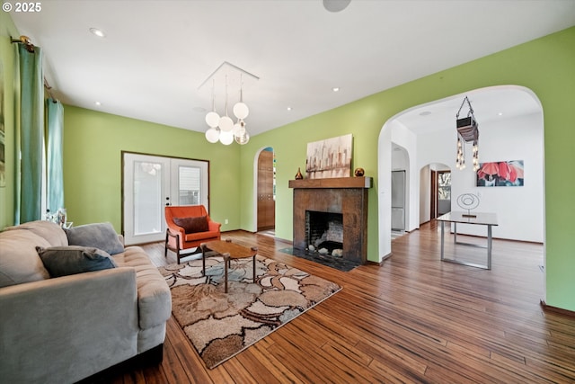 6035 NE 9th Ave, Portland, OR 97211 - living area featuring arched walkways, wood finished floors, a tiled fireplace, and recessed lighting