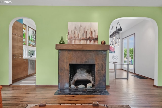 6035 NE 9th Ave, Portland, OR 97211 - living room featuring healthy amount of natural light, wood finished floors, a fireplace with flush hearth, and arched walkways