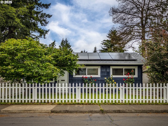 view of front of house featuring solar panels and a shingled roof