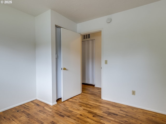 unfurnished bedroom featuring wood finished floors and baseboards