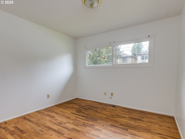 unfurnished room with light wood finished floors and baseboards