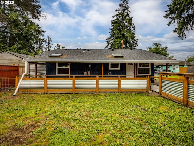 rear view of property featuring a sunroom and roof with shingles