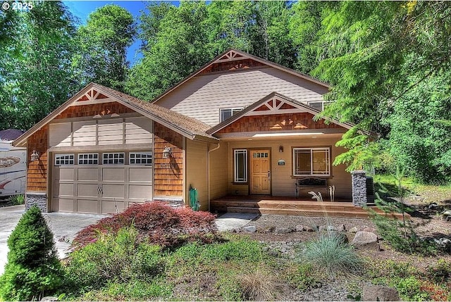 view of front of home with a porch, an attached garage, and driveway
