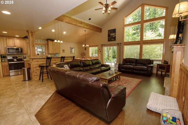 living area with recessed lighting, plenty of natural light, ceiling fan with notable chandelier, and high vaulted ceiling