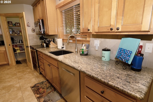 kitchen featuring tasteful backsplash, light stone countertops, a sink, light tile patterned floors, and stainless steel appliances