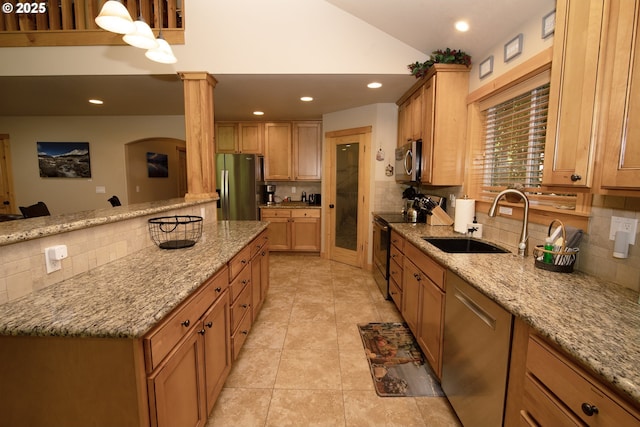 kitchen featuring decorative backsplash, recessed lighting, light stone counters, a sink, and appliances with stainless steel finishes