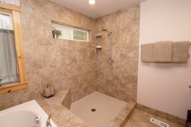 bathroom with visible vents, plenty of natural light, tiled shower, and a bath