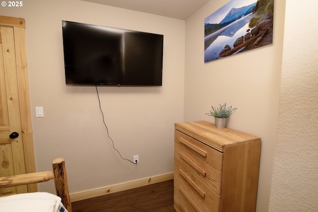 bedroom with baseboards and dark wood-style flooring