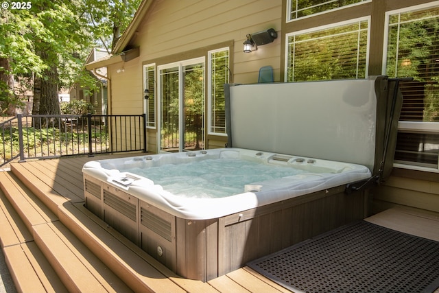 wooden terrace featuring hot tub deck surround