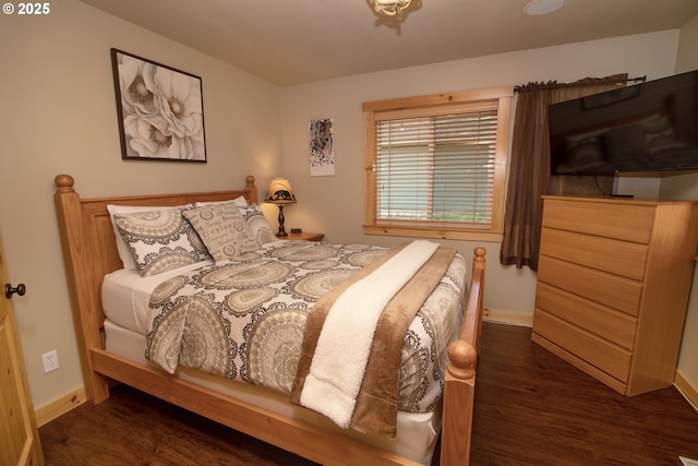 bedroom with baseboards and wood finished floors