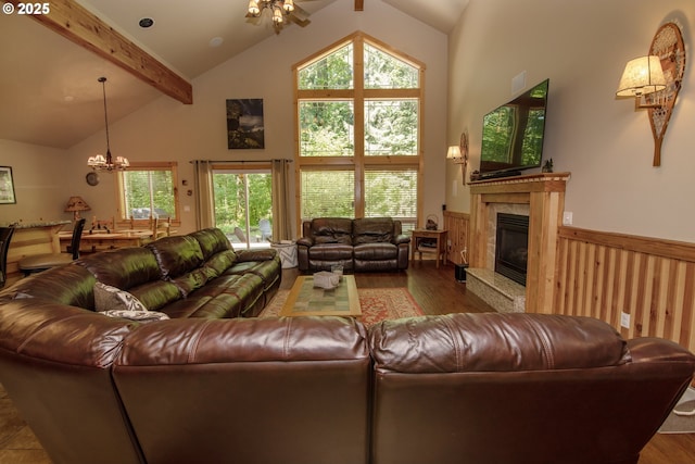living area featuring a high end fireplace, wood finished floors, a chandelier, and beamed ceiling