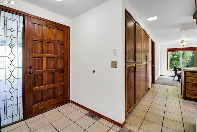 entrance foyer with baseboards and light tile patterned flooring