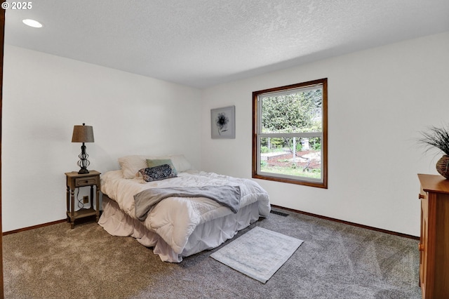 bedroom with baseboards, carpet, a textured ceiling, and visible vents