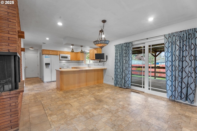 1604 NE 153rd Pl, Portland, OR 97230 - kitchen featuring white appliances, light stone finish flooring, recessed lighting, light countertops, and a peninsula