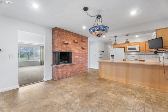 1604 NE 153rd Pl, Portland, OR 97230 - kitchen with white appliances, stone tile floors, recessed lighting, a peninsula, and a fireplace