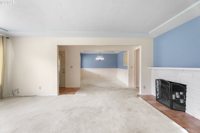 1604 NE 153rd Pl, Portland, OR 97230 - unfurnished living room with a textured ceiling, carpet, a brick fireplace, and a chandelier