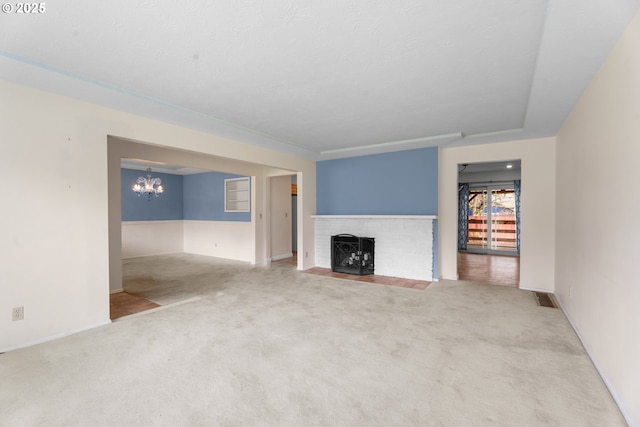 1604 NE 153rd Pl, Portland, OR 97230 - unfurnished living room with carpet floors, a fireplace, and a chandelier