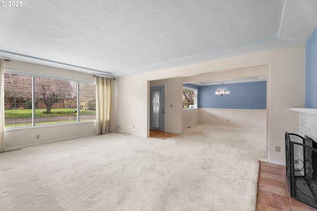 1604 NE 153rd Pl, Portland, OR 97230 - unfurnished living room with a chandelier, a textured ceiling, a fireplace, and carpet flooring