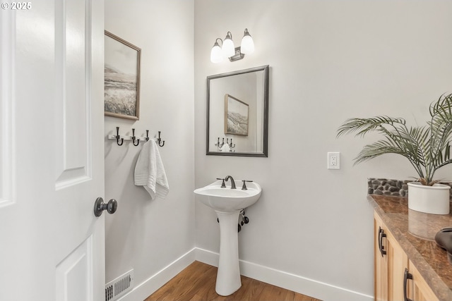 bathroom with wood finished floors, visible vents, and baseboards