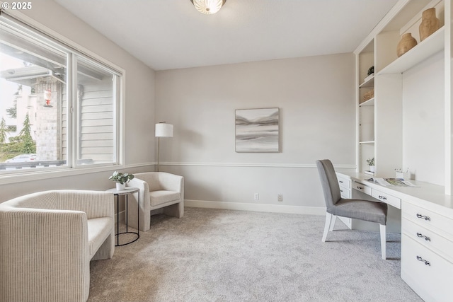 carpeted home office featuring baseboards and built in desk