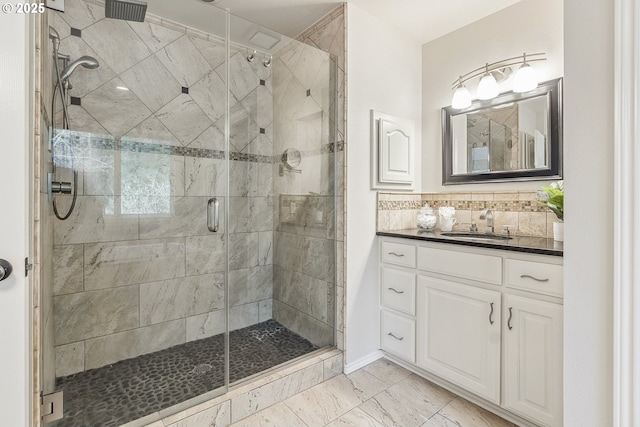 bathroom with tasteful backsplash, marble finish floor, a shower stall, and vanity