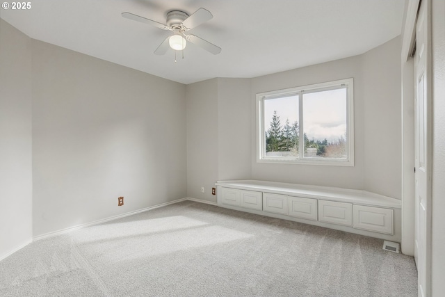 unfurnished room featuring baseboards, a ceiling fan, visible vents, and light colored carpet